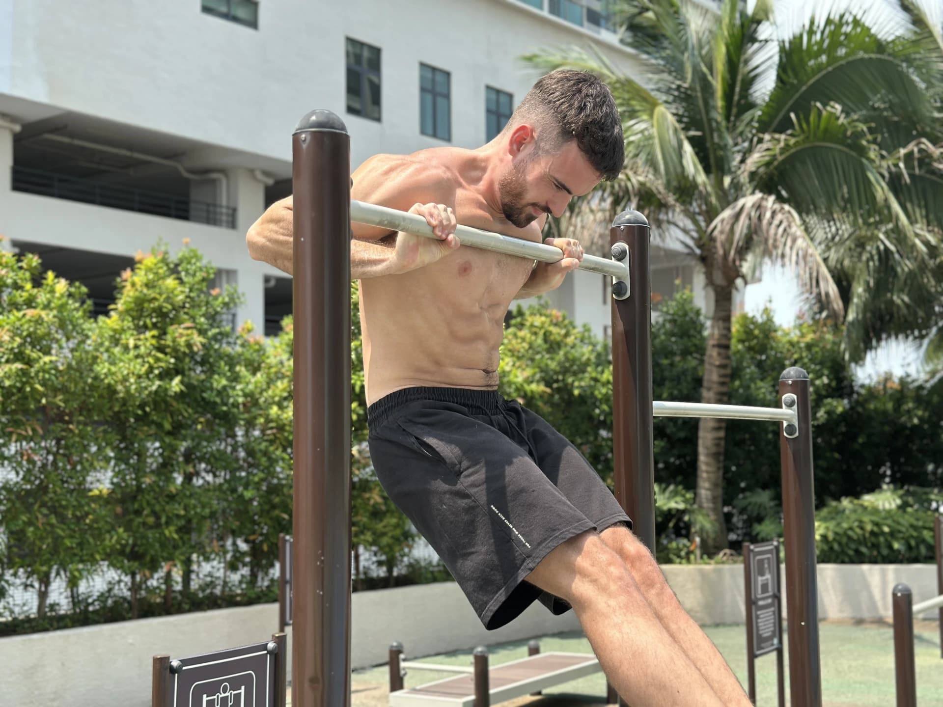 Pratiquant qui bloque dans la transition du muscle-up — cadrage frontal